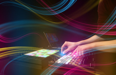 Hand mixing music on midi controller with colorful vibe concept
