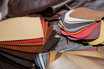 Pieces of leather and colored leather samples in the craftman's workshop. 