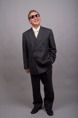 Obraz na płótnie Canvas Portrait of mature Asian businessman against gray background