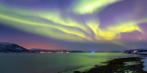 Snow storm on the empty road - Snow covered road on a winter - Northern lights in the sky over Tromso, Norway