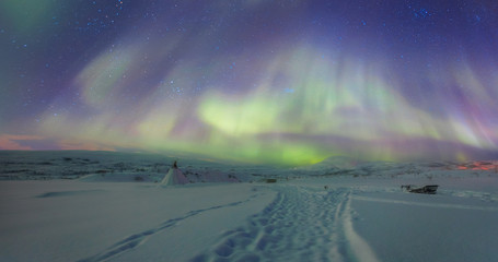 Snow storm on the empty road - Snow covered road on a winter - Northern lights in the sky over Tromso, Norway