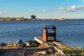 Naklejka premium The hull of the old winch on the shore in the village of Rabocheostrovsk, Kem. White Sea, Kemsky District, Republic of Karelia, Russia