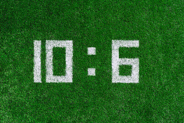 Football score 10:6.White numbers ten and six are drawn on the green grass,creative scoreboard
