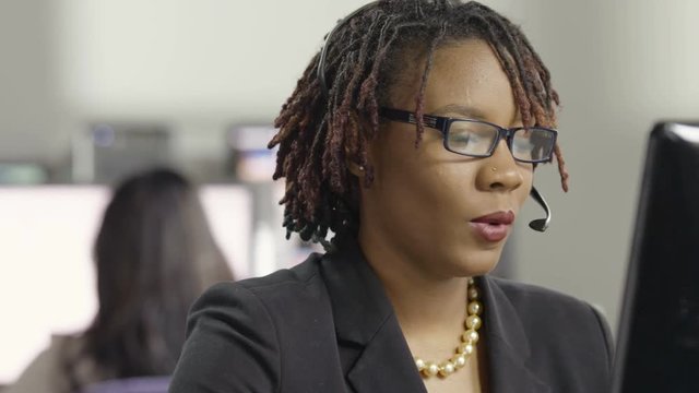 Young female customer service representative talking with headphones