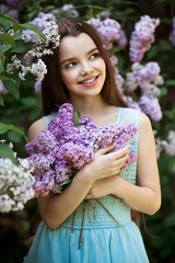 .Beautiful girl in lilac Garden. Girl with lilac flowers in springtime. Gardening.