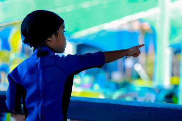 Children in swimming suits look for something.