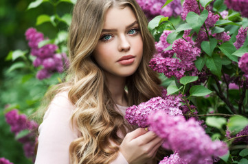 Beautiful girl in lilac Garden. Girl with lilac flowers in springtime. Gardening.
