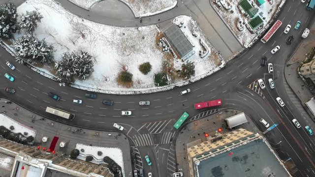 Aerial shot of roundabout smooth flow in Dalian. Moving along with cars and traffic from above. China,  Liaoning Province. Snow winter.
