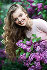 Beautiful girl in lilac Garden. Girl with lilac flowers in springtime. Gardening.