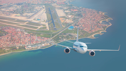 A passenger airplane is flying over istanbul city with blue sea