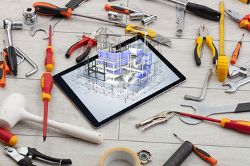 Tablet with construction tools and 3d house plan concept
