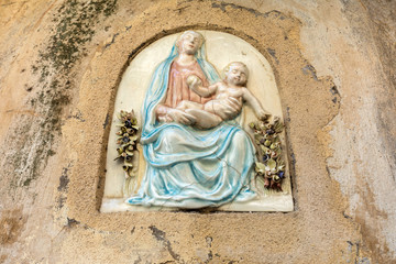 Ceramic bas-relief of the Virgin Mary with Jesus on the wall of the house in Ravello. Amalfi Coast. Italy
