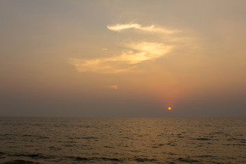 ocean under a bright purple sunset sky with sun