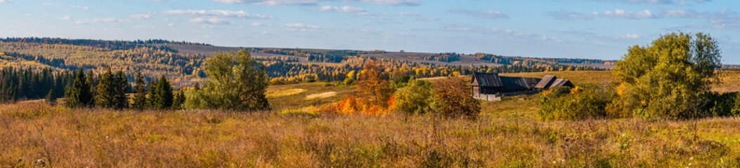 Fototapeta premium Panoramiczny widok starego wiejskiego domu i pola w słoneczny dzień, z chmurami na niebie, panorama z kilku kadrów, Stone Hill, Mari El, Rosja