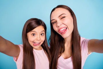 Self-portrait of two nice cute charming attractive lovely winsome cheerful cheery comic childish straight-haired girls having fun isolated on bright vivid shine green blue turquoise background