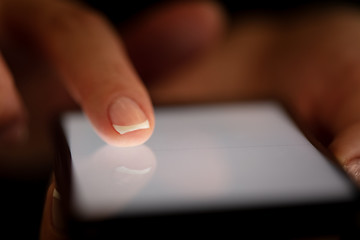 Finger touching phone with dark background with copyspace
