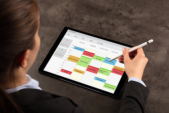 Business woman schedule her weekly program on tablet
