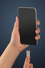 Close-up view of hand charging smartphone
