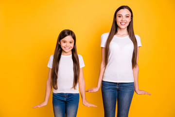 Fototapeta premium Close up photo two beautiful her she diversity lady different age buddies hold hands arms sides attractive appearance wear casual white t-shirts jeans denim clothes isolated yellow bright background