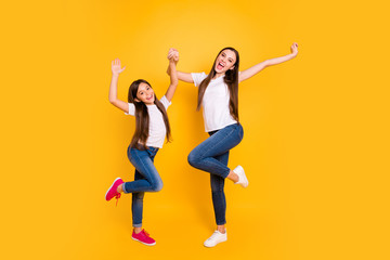 Fototapeta na wymiar Full length body size photo two beautiful her she diversity lady different age hands arms raised up scream shout yell yeah wear casual white t-shirts jeans denim isolated yellow bright background
