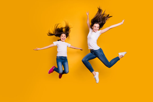 Full length body size photo beautiful her she diversity different age lady weekend mood spend free time together jump high hair flight wear casual white t-shirts jeans denim isolated yellow background