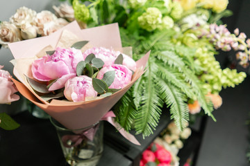Flower shop concept. Glass vases with different flowers on the shelves of the refrigerator...