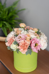 beautiful fresh bouquet of mixed flowers in round box . The work of the florist at a flower shop. Floral delivery
