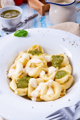 Tortellini di formaggio with basil pesto and cheese sauce