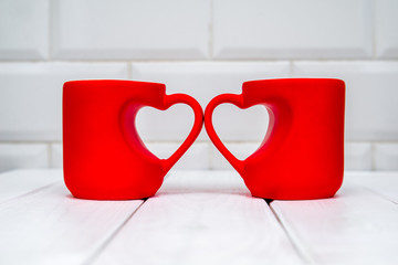 two heart shaped mugs with tea on white background 