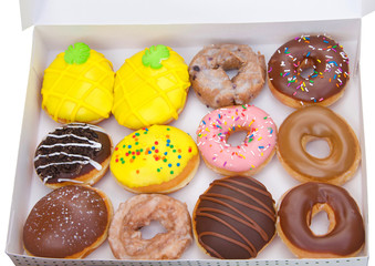 Top view flat lay of one dozen various plain and fancy donuts in a white box isolated. Are donuts...