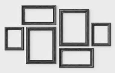 Black wooden picture or photo frames on white wall with shadows