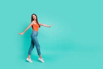 Fototapeta na wymiar Full length side profile body size photo beautiful her she lady wondered look empty space easy-going weekend walking park wear orange tank-top jeans denim isolated bright teal turquoise background