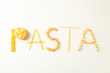 Inscription pasta on white background, space for text. Dry uncooked whole pasta