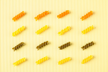 Flat lay composition with color pasta on light background, space for text