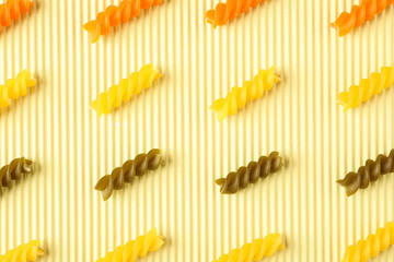 Flat lay composition with color pasta on light background, space for text and closeup