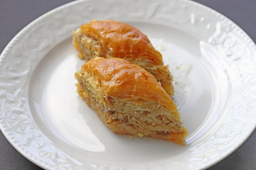 TÜRKÇE Beyaz tabak içerisnde cevizli baklava tatlısı 45 / 10000 İNGİLİZCE Çeviri yap:GoogleBing Dessert baklava with walnuts in a white dish
