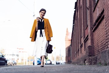 Happy young business woman walking on the street.