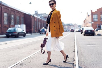 Happy young business woman walking on the street.
