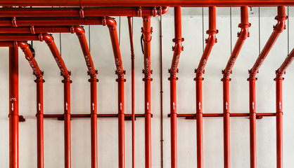 red color metal pipe on white wall - obrazy, fototapety, plakaty