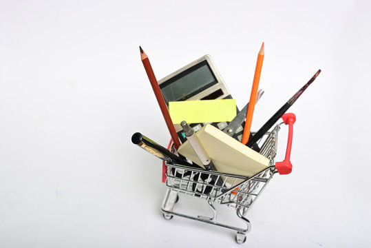 Shopping cart full with education goods for study om white background