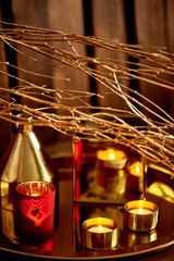 Cozy decor. Gold and red. Burning candles, Golden vessels