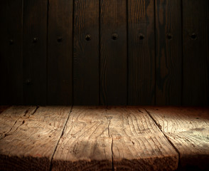 Selected focus empty brown wooden table and wall texture or old black brick wall blur background...