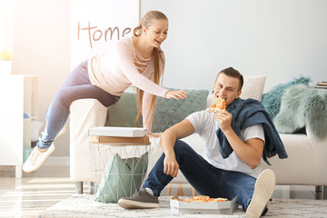 Young couple with tasty pizza at home