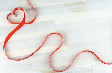 Heart of red bow on wooden background, copy space