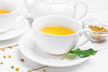 teapot and cups of tea on a white wooden background