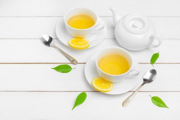 teapot and cups of tea on a white wooden background