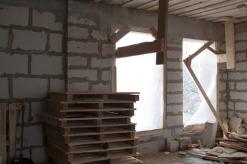 interior of a country house under construction with trim plywood. Site on which the walls are built of gas concrete blocks with wooden scaffolding