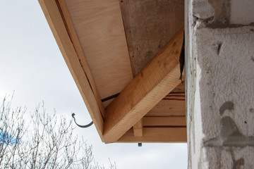 close up view of house under construction with holders for gutters water drainage system of roof