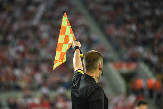 Assistant of football referee raise the flag up.