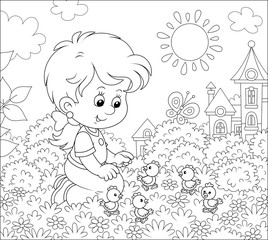 Little girl playing with small funny chicks among flowers on grass of a lawn on a sunny summer day, black and white vector illustration in a cartoon style for a coloring book